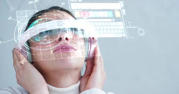 Una donna guarda con un look futuristico con gli occhiali. realtà aumentata in olografia . — Foto Stock