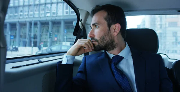 Um homem de negócios enquanto viaja de carro no banco de trás, chamadas de vídeo da família com o seu telefone móvel. O homem na carreira de motorista para suas viagens de negócio.Conceito de transporte, negócios, riqueza, tecnologia — Fotografia de Stock