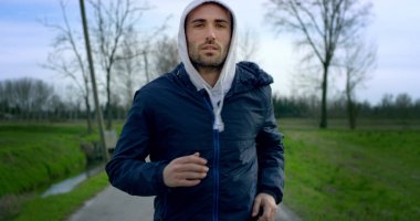 Vahşi doğanın içine küçük bir yolda çalışan ve mükemmel renkler geniş lens ile bir kamera araba hareketi ağır çekim kamera düz görünümlü genç güzel yeşil gözlü adam