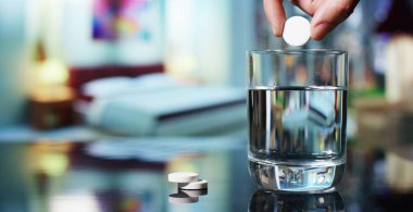Yatmadan önce bir yatak odasında bir efervesan tablet bir bardak su içinde çözülmeye yapılır. Konsept: vitamin, tıp, vücut bakımı.