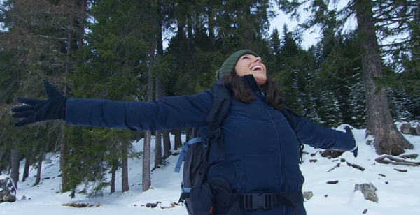 Slowmotion av en flicka promenader genom skogen och i snö, andas ren luft, leenden i naturen av berget, är promenader med vandring ryggsäck. Koncept: avkoppling, vandring, kärlek, renhet, frihet — Stockfoto