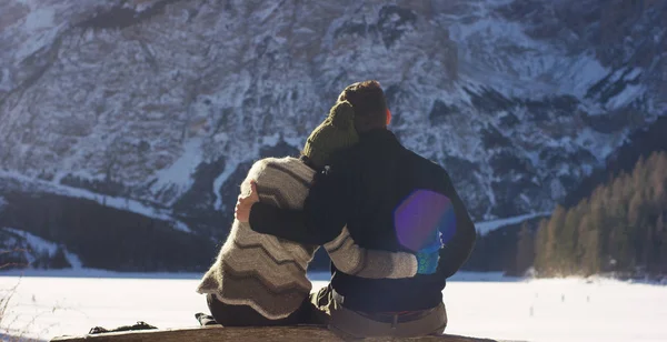 Seorang gadis beristirahat dan bersantai menyaksikan pegunungan bersalju di depan mereka memeluk dengan pacar, kekasih memeluk setelah berjalan di salju. Konsep: pegunungan, relaksasi, hiking, cinta — Stok Foto