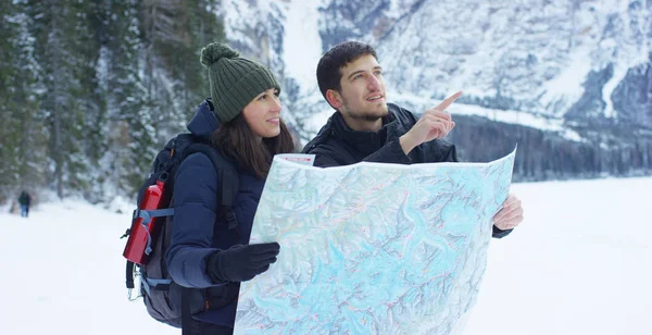 女の子は、かかっているし、ボーイ フレンド、雪の中の散歩の後の恋人を受け入れる受け入れ彼らの前に雪の山を見てリラックスします。コンセプト: リラクゼーション、ハイキング、山を愛する — ストック写真
