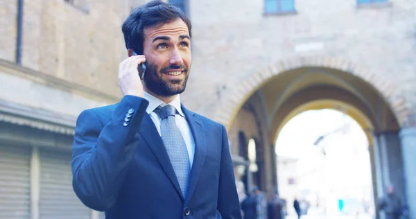 Un uomo in giacca e cravatta, che parla al telefono e sorride orgoglioso e sicuro di sé. Concetto di politica, affari, finanza, banche, assicurazioni e testimonianze per la tecnologia delle campagne politiche — Foto Stock