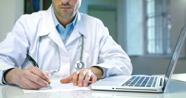 Ett Medium skjuta på grön skärm Färgtransparens av manliga unga läkare i en korridor som arbetar på ett sjukhus att skriva på skärmen inga ord och understreck med en linje med en imaginär penna. — Stockfoto
