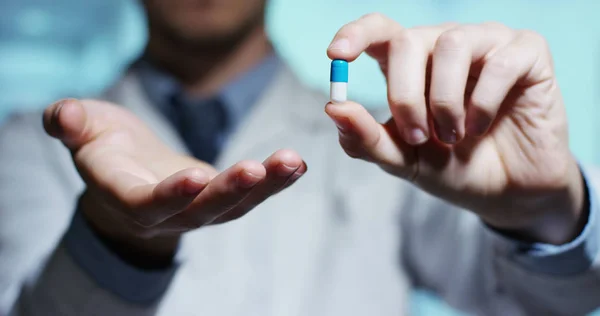 Mano de un experto médico del hospital muestra la píldora que se llevará a su paciente en cámara lenta —  Fotos de Stock