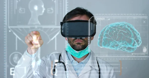 Ein Arzt, Chirurg, untersucht eine technologische digitale holographische Platte, die den Körper des Patienten, die Lungen, Muskeln und Knochen des Herzens darstellt. Konzept: Zukunftsmedizin, der menschliche Körper und die Zukunft. — Stockfoto