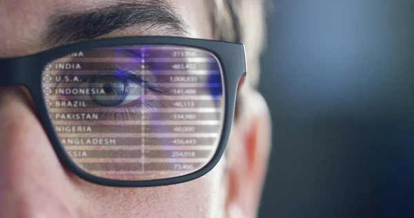 Close up of young businessman with blue eyes wearing the glasses looking at waveform lines expressing concepts of stock market, augmented reality, technology, stock exchange and finance — Stock Photo, Image