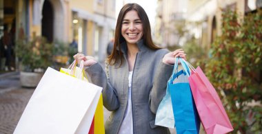 Alışveriş, şehrin içinden güzel bir kadın yürüyor dönem satış satın almaların çok mutlu. Konsept: moda, alışveriş, mutluluk ve moda blogcular