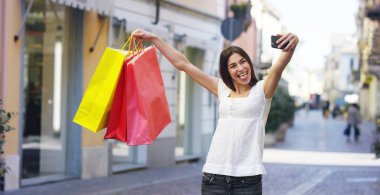 Güzel bir kadın alışveriş üzerinde fotoğraf çekme ve dönem bakiyelerini içinde onların satın almaların çok mutludur. Konsept: moda, alışveriş, mutluluk ve moda blogcular.