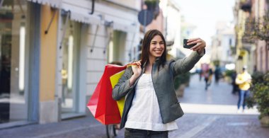 Güzel bir kadın alışveriş üzerinde fotoğraf çekme ve dönem bakiyelerini içinde onların satın almaların çok mutludur. Konsept: moda, alışveriş, mutluluk ve moda blogcular.