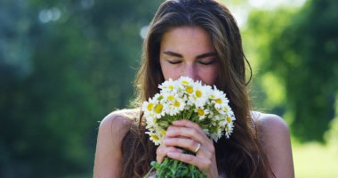 Yeşilliklerle çevrili bir kadın çiçek topladı ve bunları geçirdiği hayatını onun aşk düşünüyor hakkında düşünme düşünce, kabul. güzel anılarımız anıları geri getirmek çiçek.