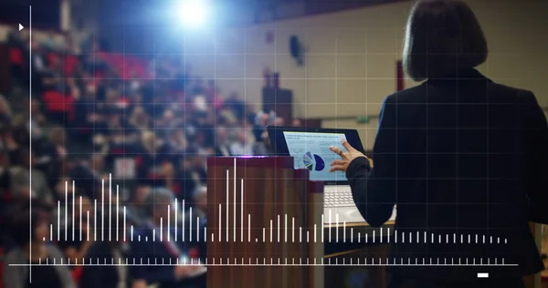 Mujer lleva a cabo un discurso ante el público en un auditorio futurista y tecnológico sobre una convención de economía y finanzas de su negocio.Concepto: economía mundial, conferencia futurista, hologramas, tecnología — Foto de Stock