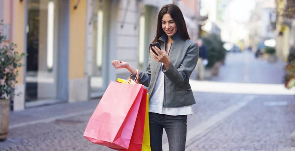 Una hermosa mujer camina por la ciudad en las compras, ella está muy feliz de las compras en el período de ventas. Concepto: moda, compras, felicidad y bloggers de moda —  Fotos de Stock