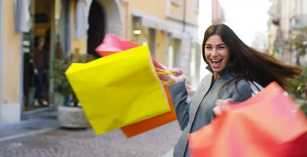 Una hermosa mujer camina por la ciudad en las compras, ella está muy feliz de las compras en el período de ventas. Concepto: moda, compras, felicidad y bloggers de moda —  Fotos de Stock