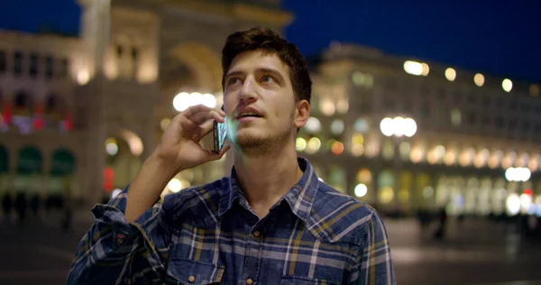 Man melihat malam di kota. Milan italy Tampan pria bisnis muda menggunakan telepon tersenyum bahagia mengenakan kemeja biru. Pria kota. . — Stok Foto