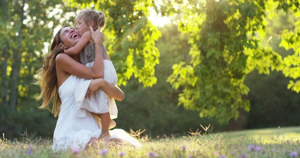 Ecologia, jovem mãe com sua adorável menina de dois anos brincando ao ar livre com amor. conceito de amor familiar da natureza. crianças felizes com o amor dos pais. conceito de verde e sustentabilidade . — Fotografia de Stock