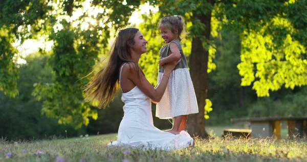 Ecología, madre joven con su adorable niña de dos años jugando al aire libre con amor. concepto de amor familiar por la naturaleza. niños felices con el amor de los padres. concepto de verde y sostenibilidad . —  Fotos de Stock