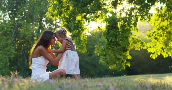 Ökologie, junge Mutter mit ihrem entzückenden zweijährigen Mädchen, das im Freien mit Liebe spielt. Konzept der Familienliebe zur Natur. glückliche Kinder mit der Liebe der Eltern. Konzept von Grün und Nachhaltigkeit. — Stockfoto