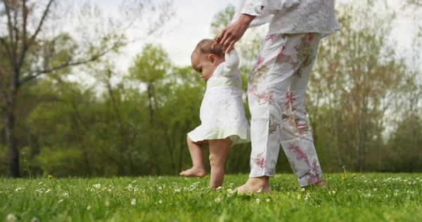 In a beautiful and happy sunny day , a mother and baby little girl play and are happy immersed in the colorful nature and happiness , the baby laughs happy . concept of happiness , love and nature. — Stock Photo, Image