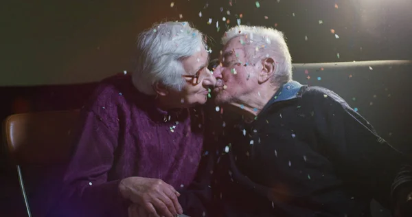Pasangan tua pada usia 90 tahun bersenang-senang dengan confetti dan berciuman dalam gerakan lambat — Stok Foto