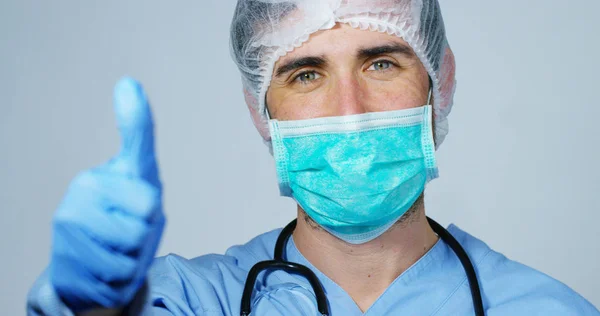 Portret van een chirurg of arts met masker en headset gereed voor gebruik in het ziekenhuis of de kliniek close-up. De chirurg glimlacht veilig en trots op zichzelf. Concept van geneeskunde, ziekenhuizen en artsen, zorg — Stockfoto