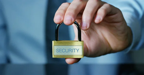 Un hombre de negocios en camisa y corbata muestra un candado con llaves como signo de seguridad.El símbolo de candado contraseña que protege los archivos del sistema de hacker tecnológico Internet o sistema bancario . —  Fotos de Stock