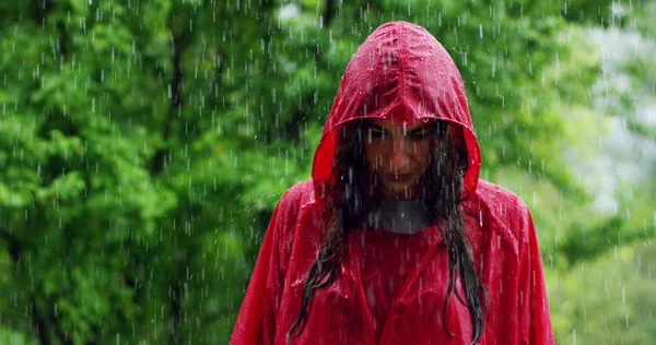 girl smiles, spins and laughs in the rain. the rain falls, the drops fall on his face and the girl is happy with life and nature around. concept of nature and happy life. Adventure, purity.