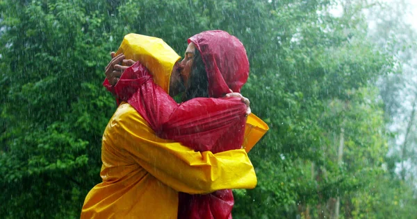 Ein Paar, Mann und Frau, tanzen, küssen und spielen fröhlich lächelnd im Regen in der Natur und drücken ihre Freiheit und ihre Liebe aus. Konzept von Liebe, Natur, Glück, Freiheit. — Stockfoto