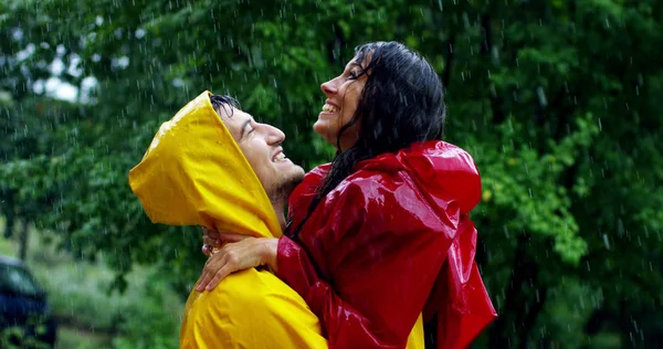 Dos adolescentes o adultos se besan bajo la lluvia como amantes. Feliz pareja de vida y naturaleza alrededor. concepto de la naturaleza y la vida feliz. Aventura, pureza . — Foto de Stock