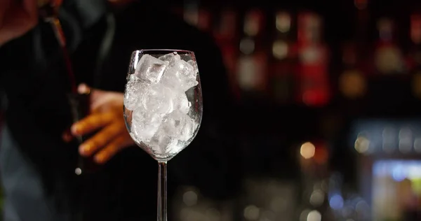 Dans une boîte de nuit ou un pub, un barman professionnel préparant un cocktail avec de la glace un mélange d'alcool. Le barman mesure les quantités pour un cocktail parfait. concept : discothèque, fun, amis, cocktail . — Photo