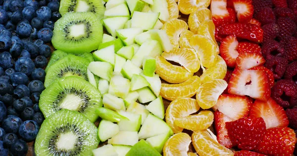 Świeżych owoców wymieszać skład, truskawka, jabłko, borówki, maliny, kiwi, pomarańcza. Sałatka z świeże i egzotyczne tropikalne owoce do jedzenia w lecie. Eksplozja kolorów, świeżość, witaminy i smak — Zdjęcie stockowe