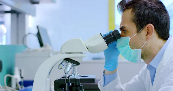 좋은 젊은 과학자 남성 의사 전문 실험실 사용 된 장비 및 눈 보호 안경을 착용 및 실험실 안경의 액체 바이러스 세포 분석 — 스톡 사진