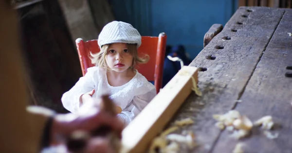 En una antigua carpintería un niño y un abuelo jugando con un concepto de avión de madera de la tradición que continúa con el tiempo y la sorpresa — Foto de Stock