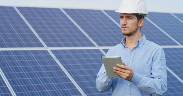 Technical expert in solar energy photovoltaic panels, remote control performs routine actions for system monitoring using clean, renewable energy. concept of remote support technology — Stock Photo, Image