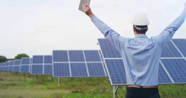 Technical expert in solar energy photovoltaic panels, remote control performs routine actions for system monitoring using clean, renewable energy. concept of remote support technology and victory. — Stock Photo, Image