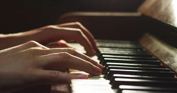 Un musicien joue du piano en lisant la partition devant. Le musicien ou compositeur écrase les touches du piano avec ses longs doigts. Concept : son, musique, académie, concert, pianiste — Photo