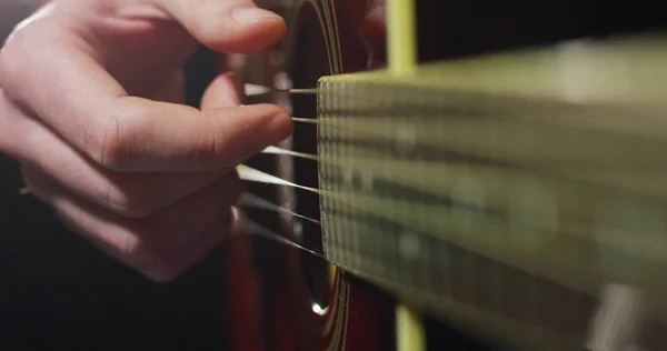 Bir müzisyen klasik gitar ve pratik-e doğru oyun daha iyi ve daha iyi oynar. Gitarist elini dizelerle kendiniyoluyor. — Stok fotoğraf