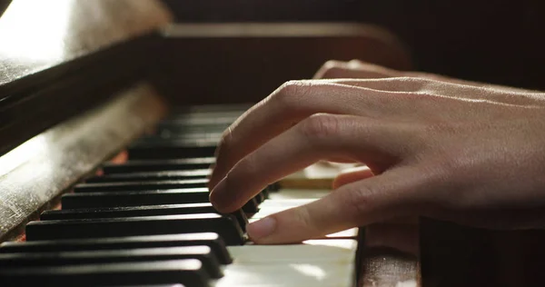 En musiker spelar piano läsning Poäng framför. Den musikern eller kompositören krossar pianotangenter med hans långa fingrar. Koncept: ljud, musik, academy, konsert, pianist — Stockfoto