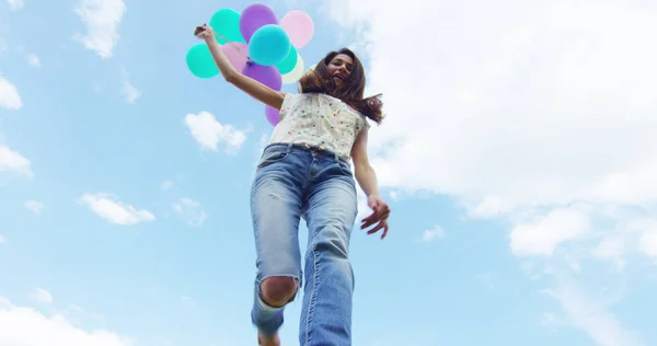 Chica de belleza con cabello largo saludable al aire libre. Feliz joven sonriente disfrutando de la naturaleza. Hermosa joven divirtiéndose con globos en el prado. Concepto de libertad. Puesta de sol — Foto de Stock