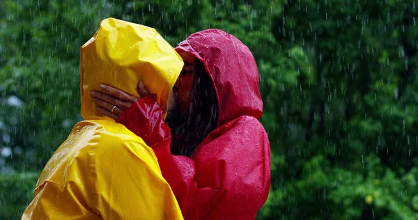 Dos adolescentes o adultos se besan bajo la lluvia como amantes. Feliz pareja de vida y naturaleza alrededor. concepto de la naturaleza y la vida feliz. Aventura, pureza . — Foto de Stock