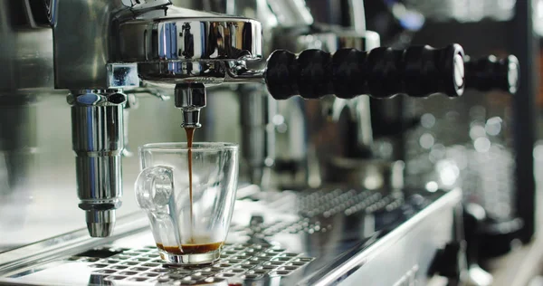 Gerakan super lambat dari kopi espresso panas mengalir ke dalam dua gelas porselen putih dari mesin kopi di 4k (top view close up ) — Stok Foto