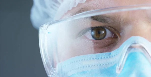 医生或外科医生在医用口罩、 呼吸器、 棕色的眼睛、 护目镜、 外科手术帽，在医院或诊所。概念： 第一次的医疗帮助，帮助治疗的人，手术，医生，健康. — 图库照片