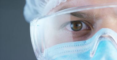Bir doktor veya cerrah tıbbi maske, solunum, kahverengi gözleri, cerrahi bir delik, bir hastane ya da bir klinik portresi.