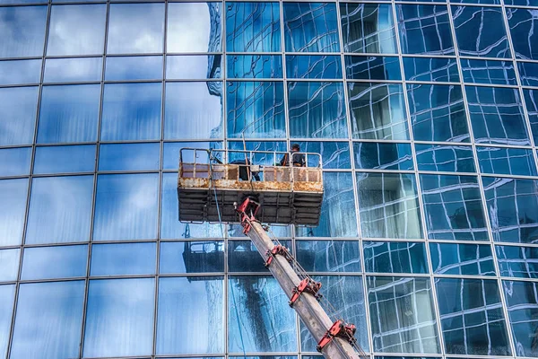 A man washes windows of a skyscraper