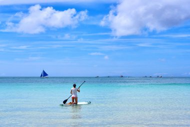 Kadın standup paddleboarding görünümde ocea üzerinde keyif alıyor
