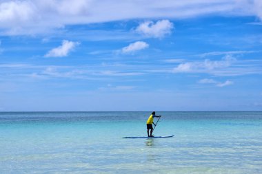 Adam okyanus üzerinde bir görünümde standup paddleboarding keyfini çıkarın