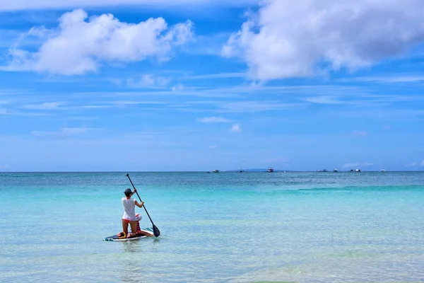 Kadın standup paddleboarding görünümde ocea üzerinde keyif alıyor