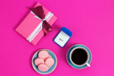 Kahve macarons ve pembe bir arka plan üzerinde halka. Evlenme, teklif hangi vermek yüzük kutusu. Üstten Görünüm, tonlu görüntü