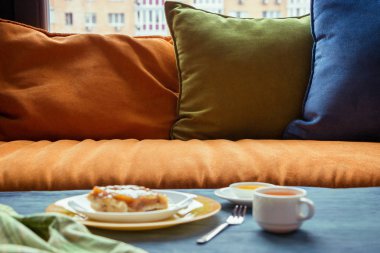 Meyveli kek pencere ve yastık yanındaki masada yeşil çay ile. Gün ışığı, seçici odak, film etkisi